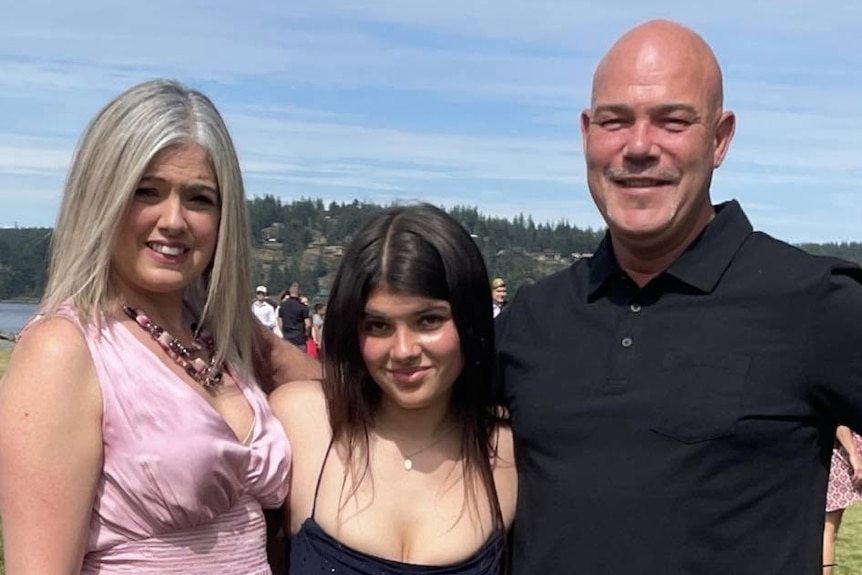 A young woman in the center of her mum and dad.