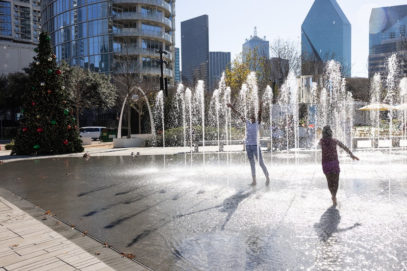 E’Nette, 12, and Emmaah Deboise, 6, of Rowlett, play in a fountain at Klyde Warren Park on...