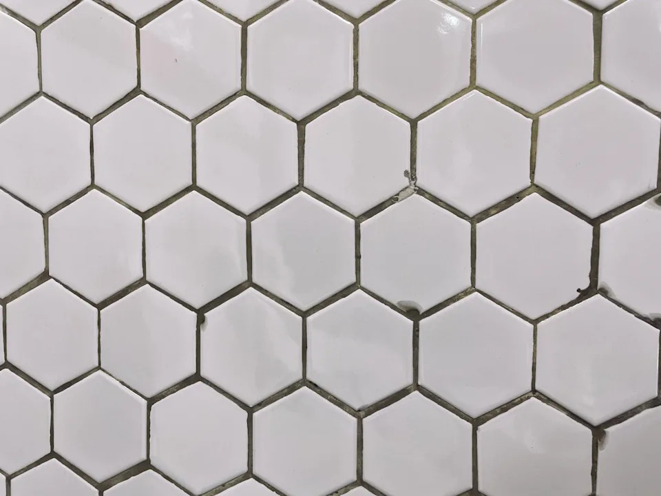 Close-up of a wall featuring white hexagonal tiles arranged in a honeycomb pattern