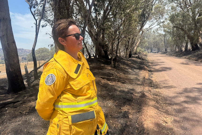 Longwood local Shona Guest on a dirt road near burnt trees.