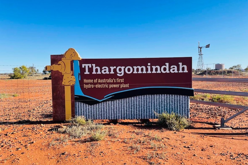 The Thargomindah town sign on the side of a dusty road. 