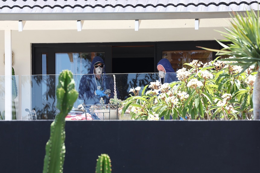 Police in forensic suit are inspecting a crime scene in a house