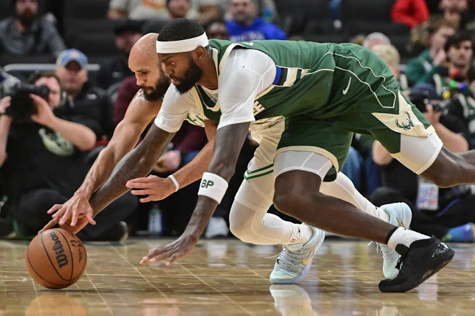 Dec 11, 2025; Milwaukee, Wisconsin, USA; Milwaukee Bucks forward Bobby Portis (9) and Boston Celtics guard Derrick White (9) reach for a loose ball in the first quarter at Fiserv Forum. Mandatory Credit: Benny Sieu-Imagn Images