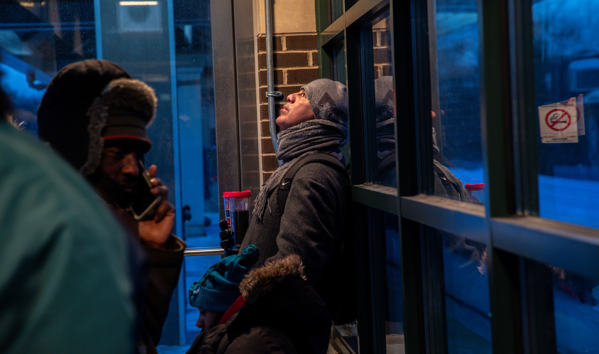 Metra Electric line commuters at the Flossmoor station listen to...