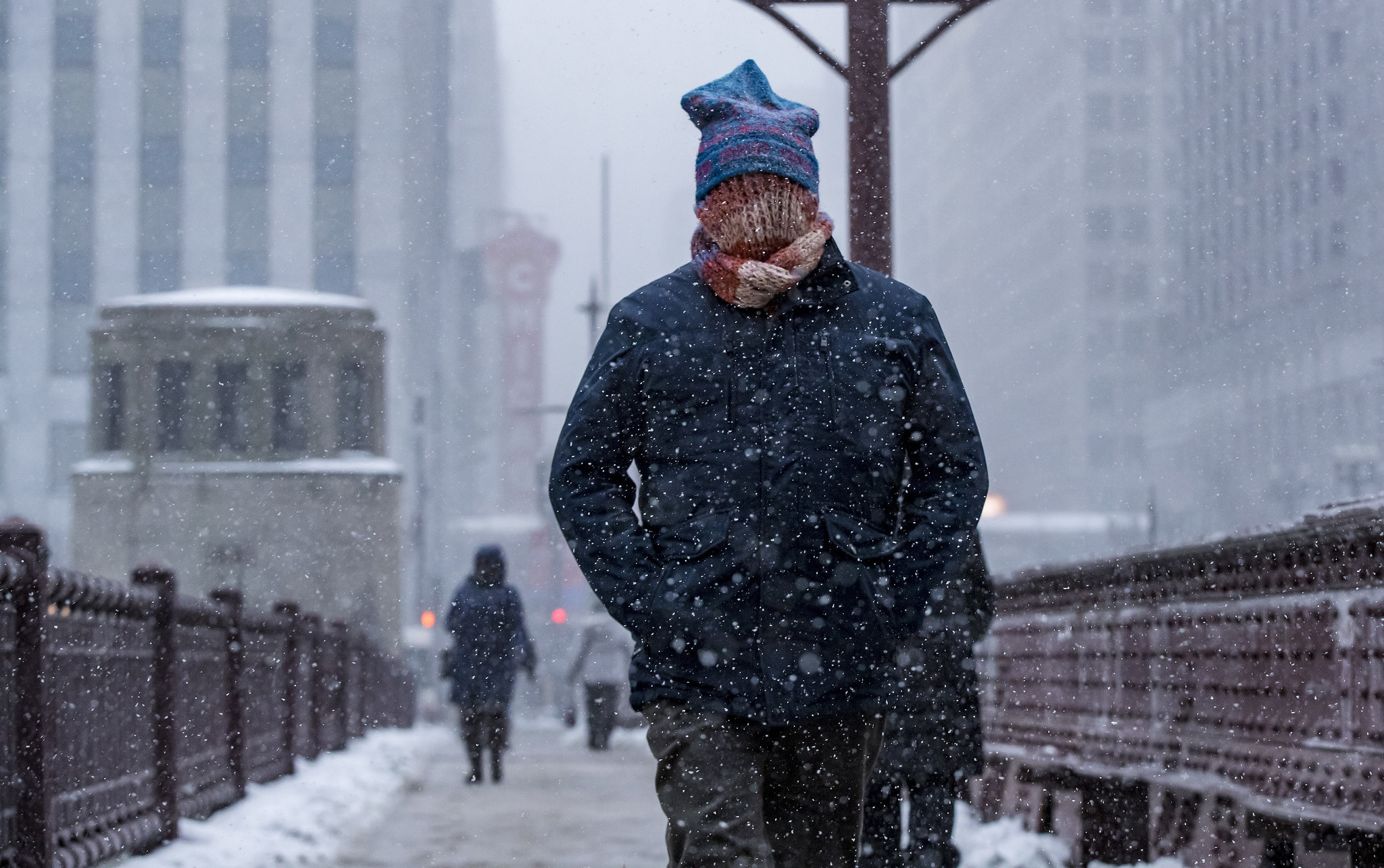 People walkÂ in temperatures near zero degrees as snow and wind...