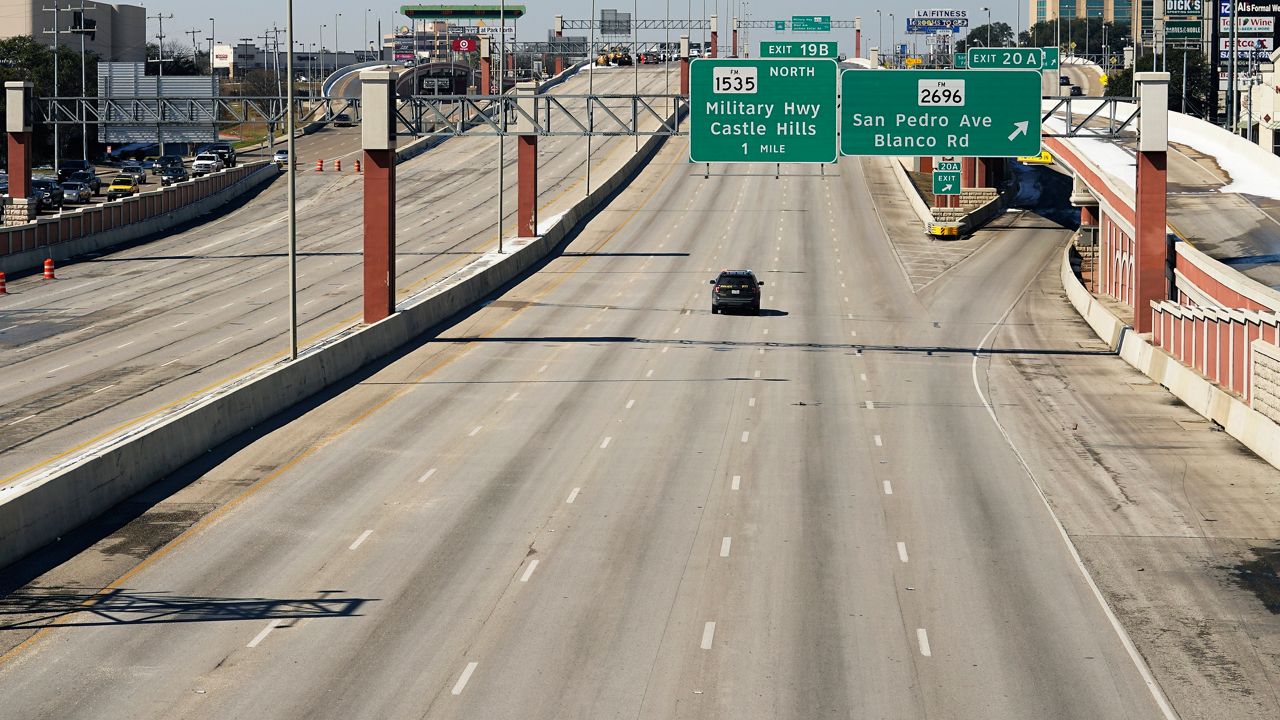 A police vehicle travels along a closed 10-lane section of Interstate 410, Friday, Feb. 19, 2021, in San Antonio. Many roads, highways and interstates remain closed to to icy conditions. (AP Photo/Eric Gay)