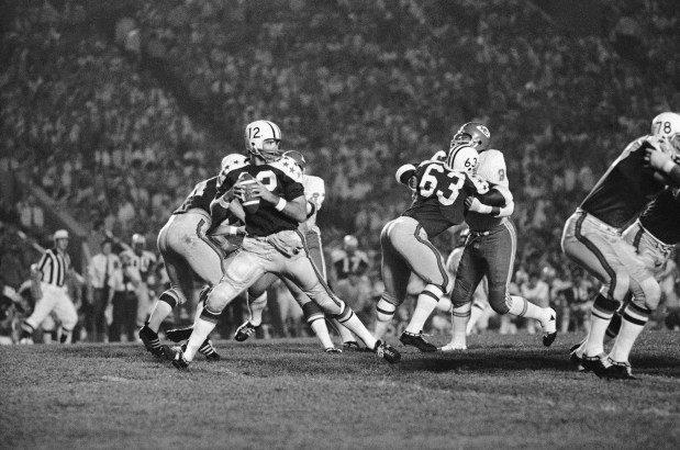 All-Star quarterback Dennis Shaw (12) sets to throw a pass in the first quarter of action against the Kansas City Chiefs in the College All-Star game, Friday, July 31, 1970, Chicago. Shaw got the pass away ahead of the rush, but throw fell incomplete. The rest of the players are unidentified. (AP Photo/James Palmer)