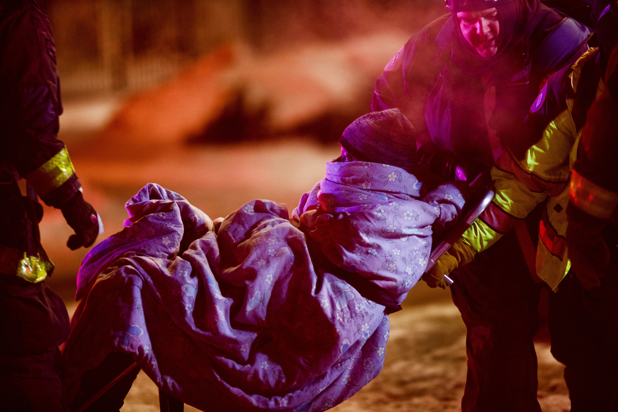 Firefighters moveÂ a person toÂ a waiting ambulance at the scene of...