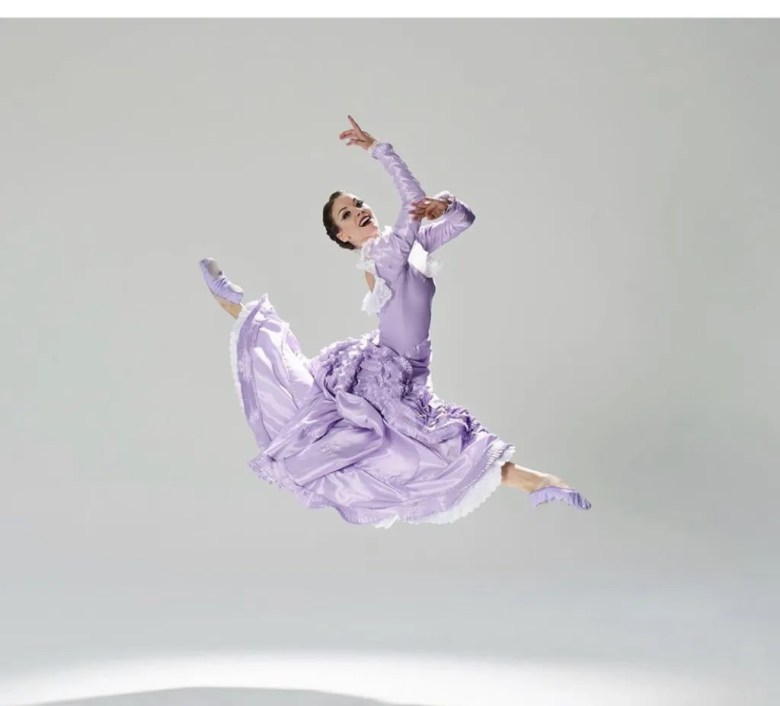 Anne O'Donnell Passero is shown in a lavender 19th-century-style dress midleap.