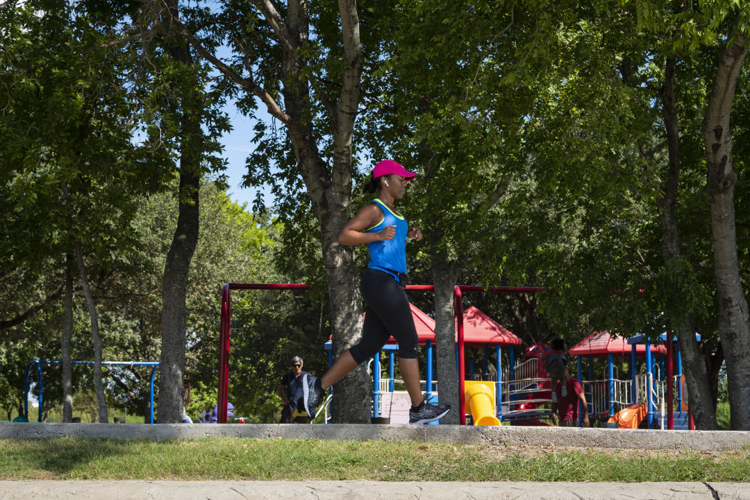 Woman running along a trail at Arthur Storey Park.