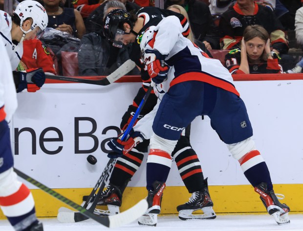 Blackhawks left wing Nick Lardis gets squeezed on the wall by Capitals right wing Justin Sourdif, right, in the third period at the United Center on Jan. 9, 2026, in Chicago. (John J. Kim/Chicago Tribune)