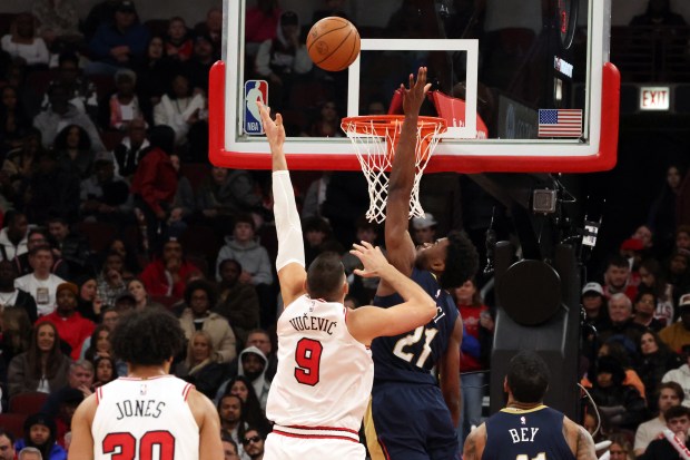 Bulls center Nikola Vučević (9) tosses the ball above the reach of Pelicans center Yves Missi (21) in the second half at the United Center on Wednesday, Dec. 31, 2025. The Bulls won 134 - 118. (Terrence Antonio James/Chicago Tribune)