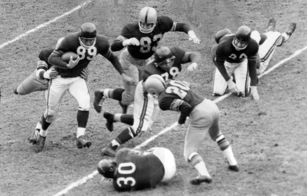 The bruising ground power of the Chicago Bears is typified in this action picture made in Nov. 6, 1955. John Hoffman of the Bears is being hauled down by the Green Bay Packers but Hoffman already smashed for a 6-yard gain. The tackle is made by Deral Teteak, guard Stan Jones (78) blocks for Hoffman, followed by Bill McColl (83). Chick Jagade (30) also threw a block before he went down. Packers are John Martinkovic (8) and Billy Bookout (20). The Bears gained 410 yards on the ground. Bears won 52-31. (Maurice Rohde/Chicago American)