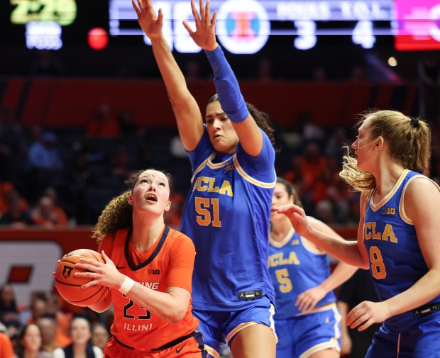 UCLA Bruins center Lauren Betts (51) towers over Illinois Fighting Illini forward Berry Wallace (23) as she drives to the basket in the second half during a game between the Illinois Fighting Illini and the UCLA Bruins at State Farm Center on Jan. 28, 2026, in Champaign. The Bruins beat the Fighting Illini 80-67. (Stacey Wescott/Chicago Tribune)