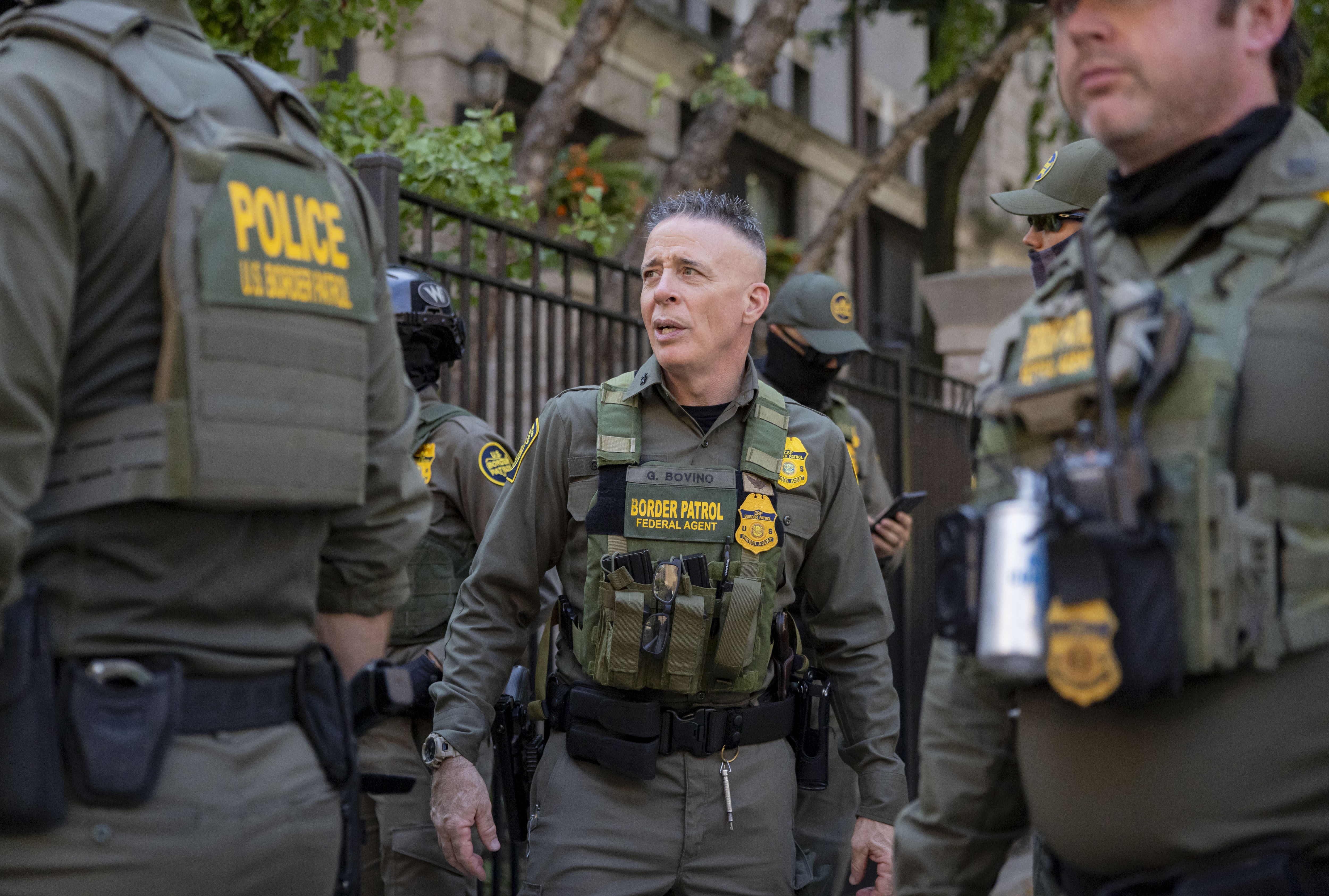 Gregory Bovino, center, a U.S. Border Patrol official, stands with...