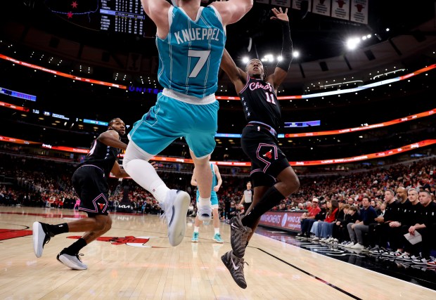 Chicago Bulls guard Ayo Dosunmu (11) tries to intercept a pass from Charlotte Hornets guard/forward Kon Knueppel (7) as Knueppel falls out of bounds in the first half of a game at the United Center in Chicago on Jan. 3, 2026. (Chris Sweda/Chicago Tribune)