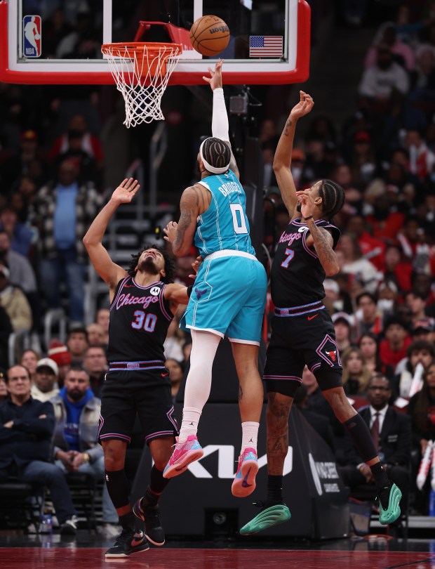 Charlotte Hornets forward Miles Bridges (0) scores while being fouled in the second half of a game against guard Tre Jones (30), forward Dalen Terry (7), and the Chicago Bulls, at the United Center in Chicago on Jan. 3, 2026. (Chris Sweda/Chicago Tribune)