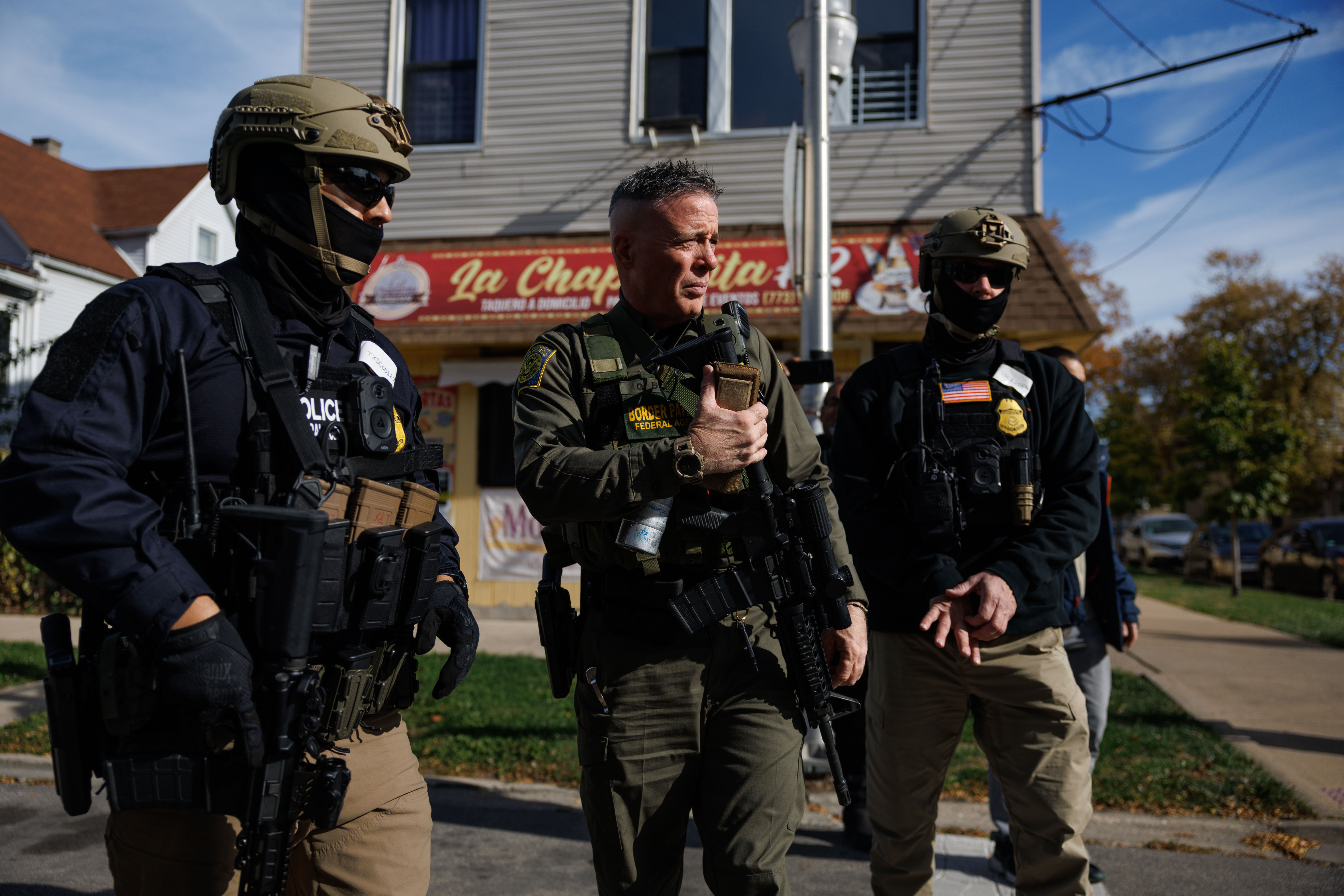 Border Patrol Cmdr. Gregory Bovino, center, walks with other agents...