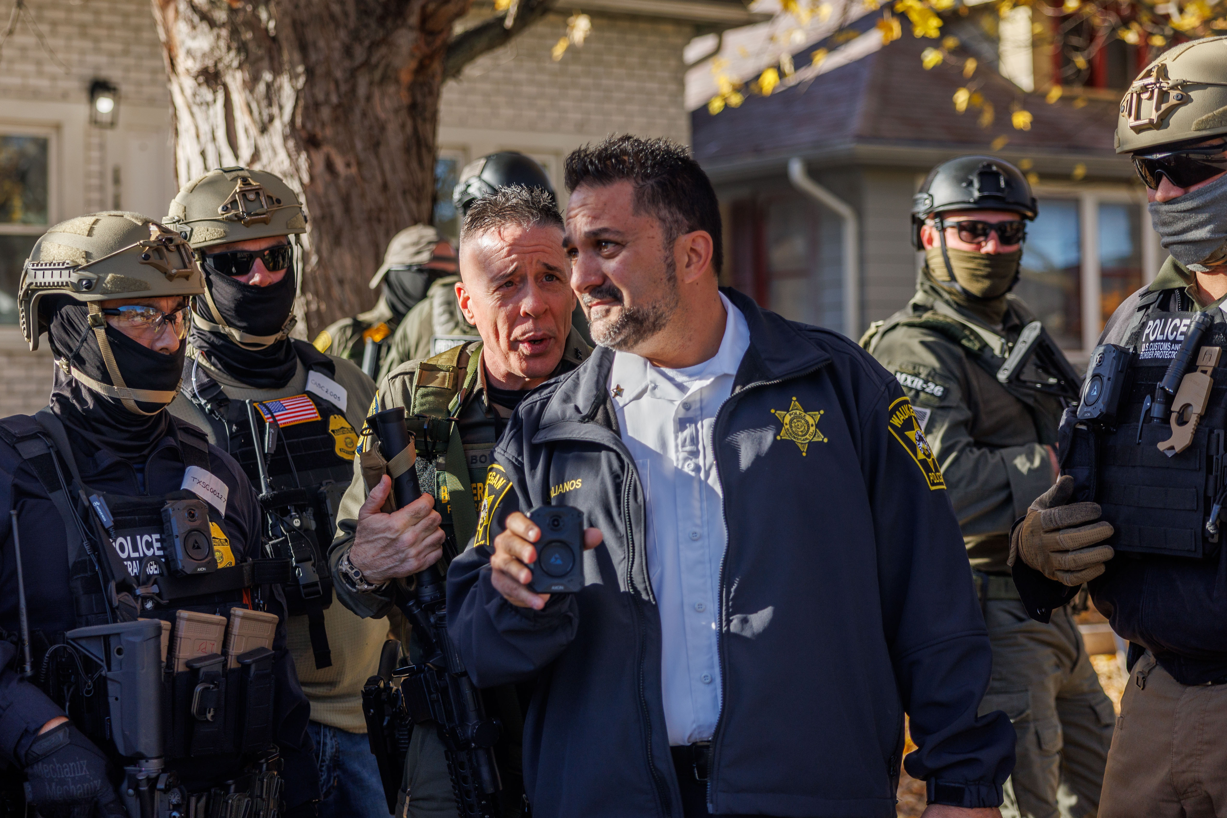 Border Patrol Cmdr. Gregory Bovino talks with a Waukegan police...