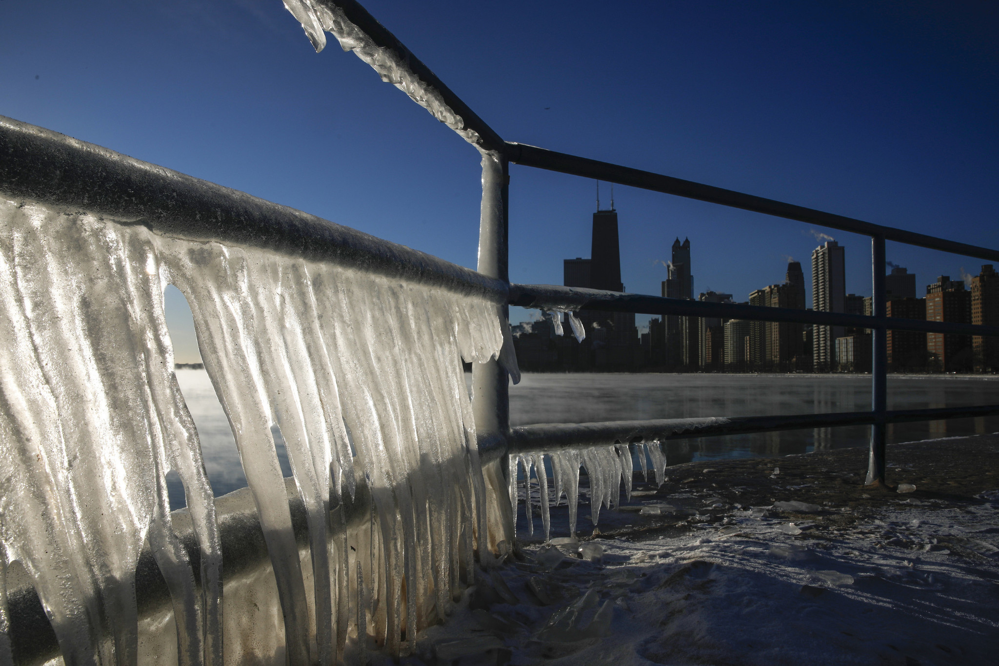 Ice forms on a railing at North Avenue Beach as...