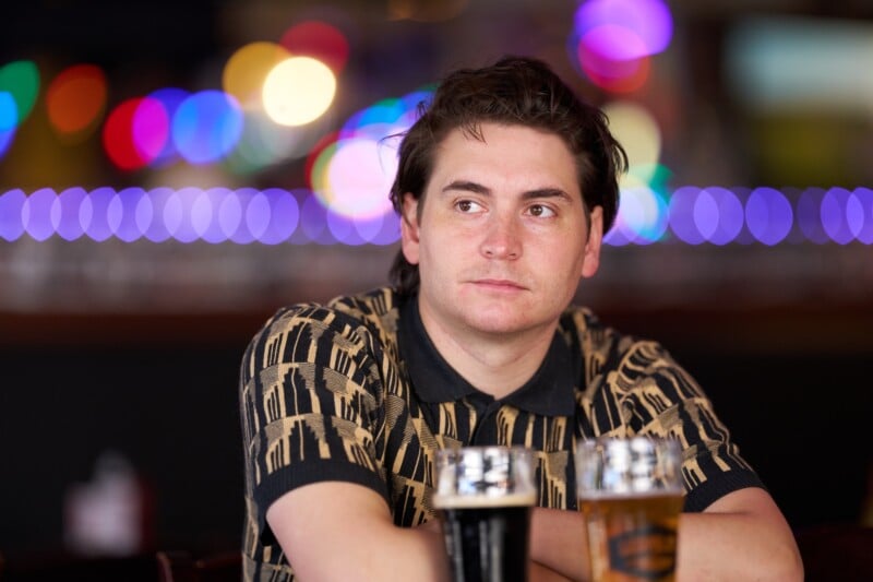A man sitting at a table with two glasses of beer.