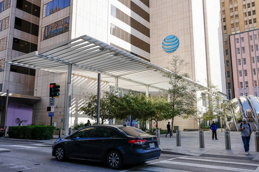 A car drives past AT&T headquarters building Whitacre Tower and the AT&T Discovery District...
