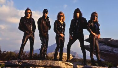 Judas Priest standing on rocky ground with a mountain behind them