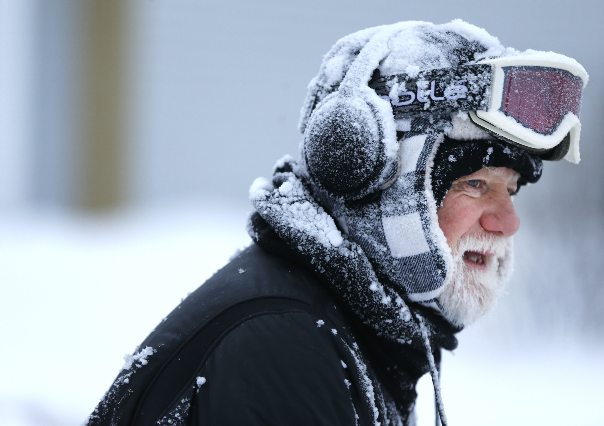 Don Milliken, of Palatine, clears snow from his neighbors' sidewalks...