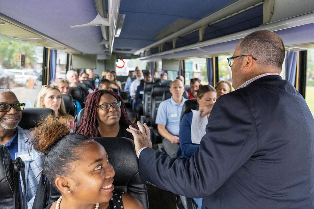 Folds speaks to a bus tour of supporters, sharing progress on active projects