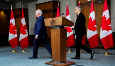 Ontario Premier Doug Ford leads Prime Minister Mark Carney off stage to the right leave following an announcement on Parliament Hill in Ottawa.