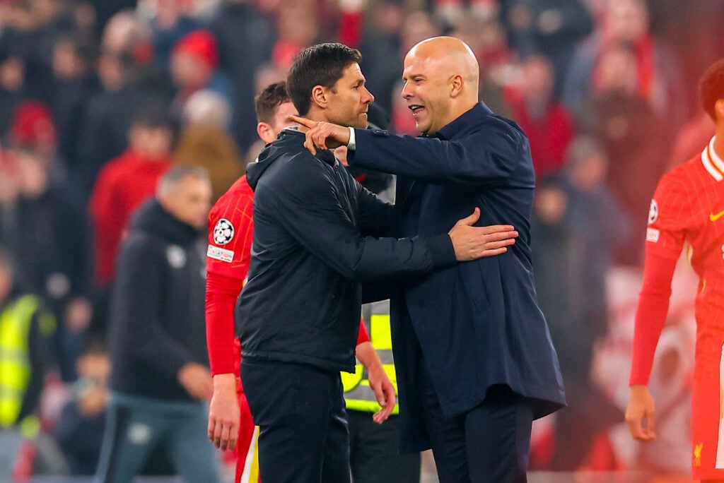Xabi Alonso and Arne Slot embrace after Liverpool's UEFA Champions League match against Bayer Leverkusen at Anfield.