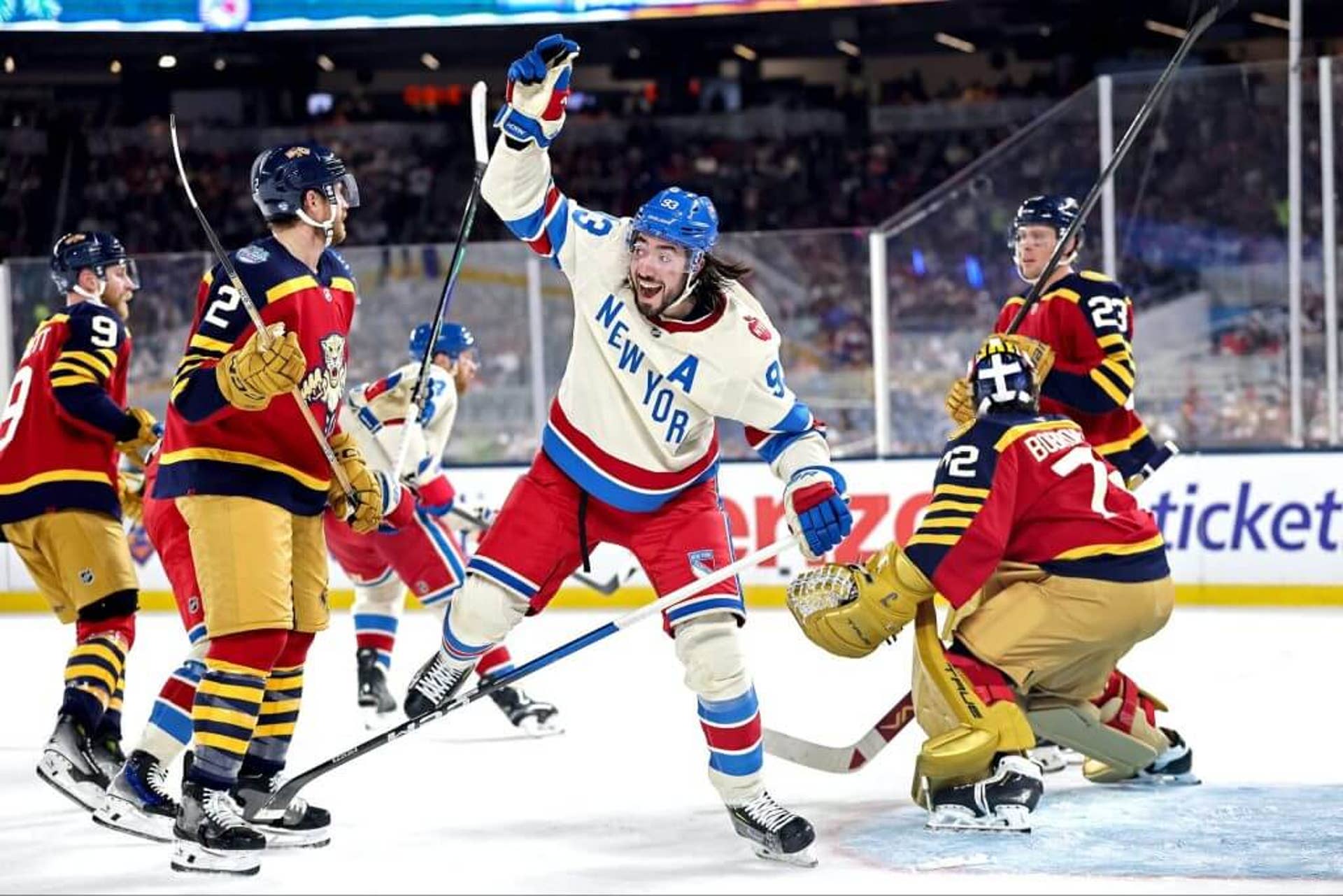 Mika Zibanejad of the New York Rangers celebrates a goal against the Florida Panthers among of group of them on the ice.