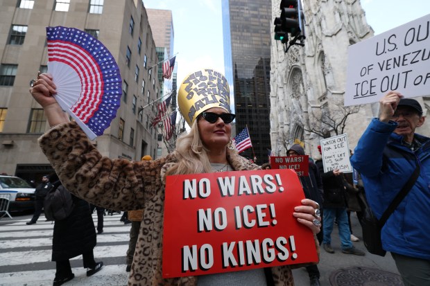 People hold signs as they participate in a protest organized by Rise and Resist against US Immigration and Customs Enforcement (ICE) activities and the US intervention in Venezuela in New York on January 11, 2026. (Photo by TIMOTHY A. CLARY / AFP via Getty Images)