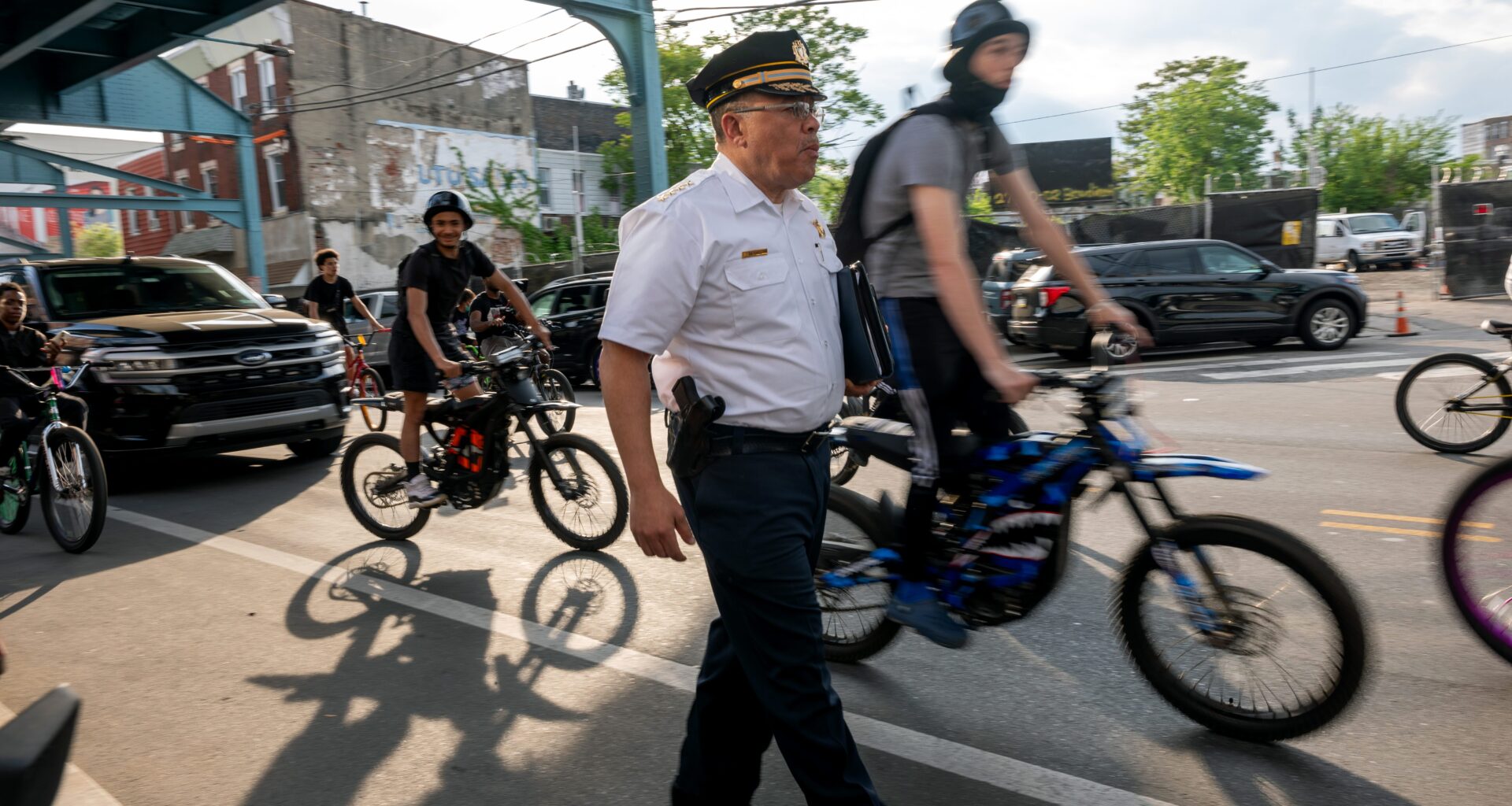 Philadelphia Police Commissioner Kevin Bethel walks through Kensington, flanked by bicyclists.