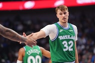 Dallas Mavericks forward Cooper Flagg (32) gets a congratulations from a teammate during the...