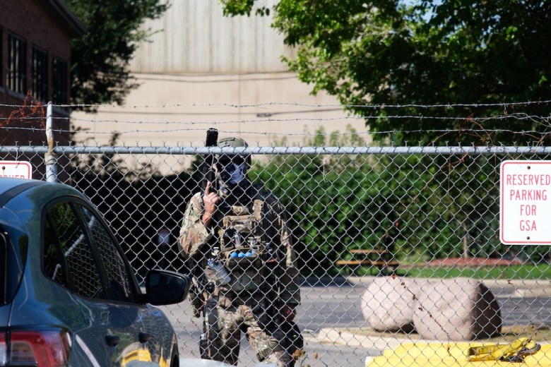 A Customs and Border Patrol agent guards a fence outside an ICE detention center in Chicago.
