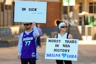 Ryan Safdarinia, left, and Lillian McCall hold signs reacting to the news that the Dallas...