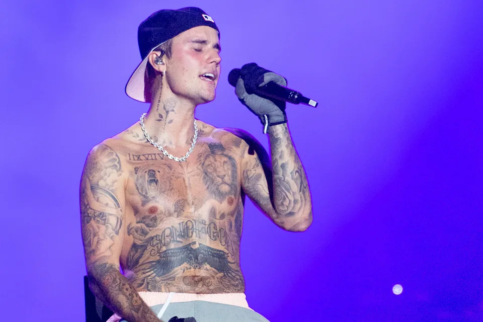 Justin Bieber performs, shirtless, onstage.
