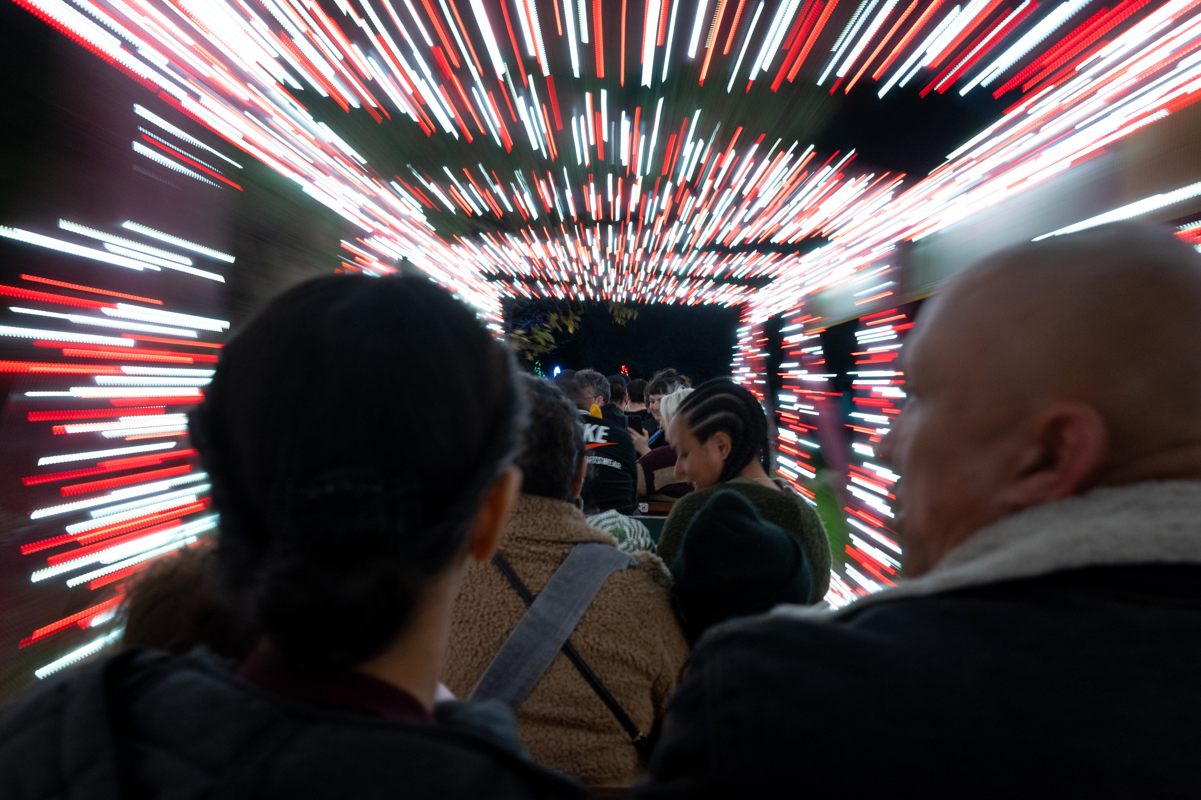 Passengers are surrounded by lights on a tour of holiday...