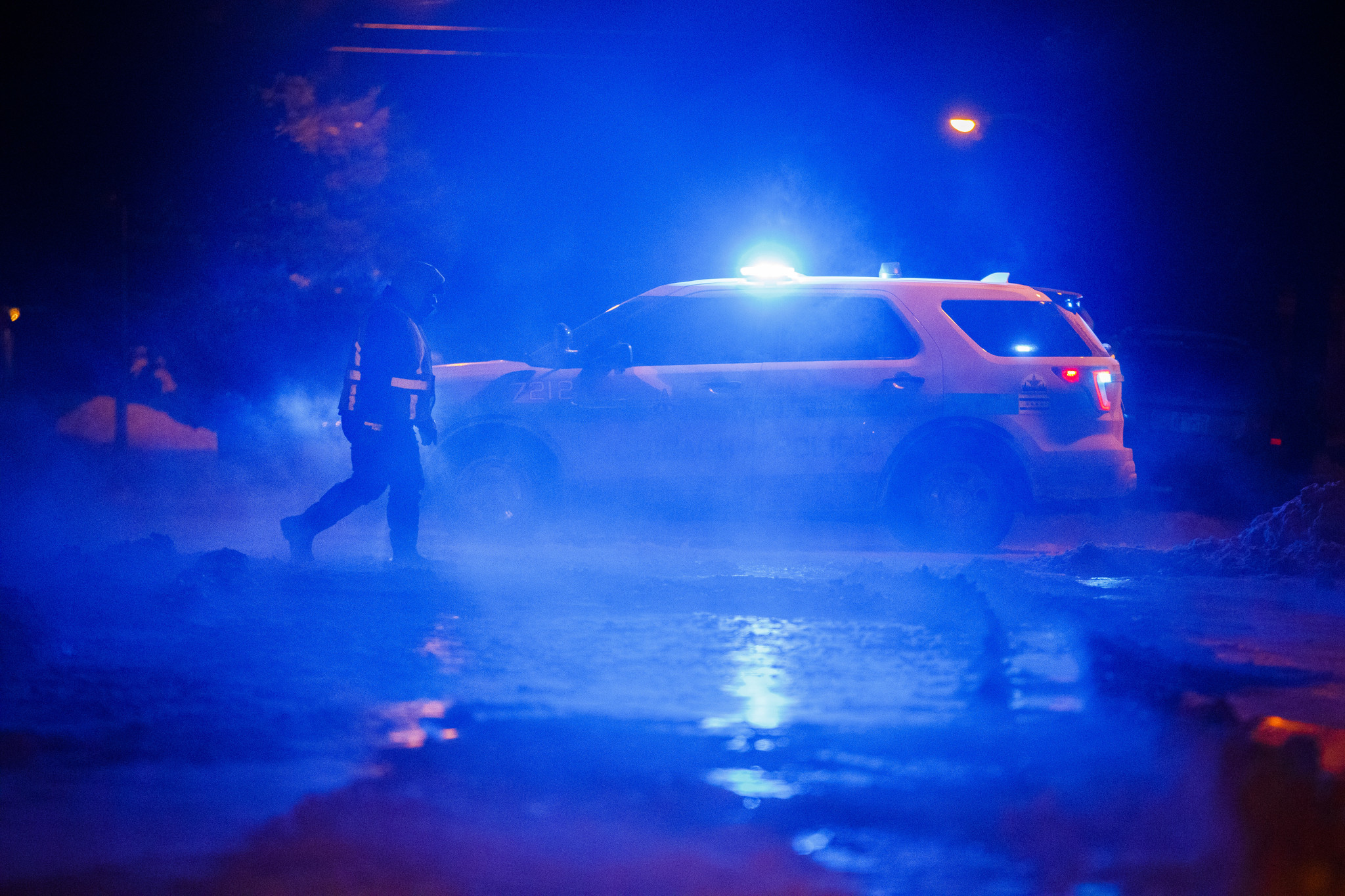 Crews and police work the scene of a broken water...
