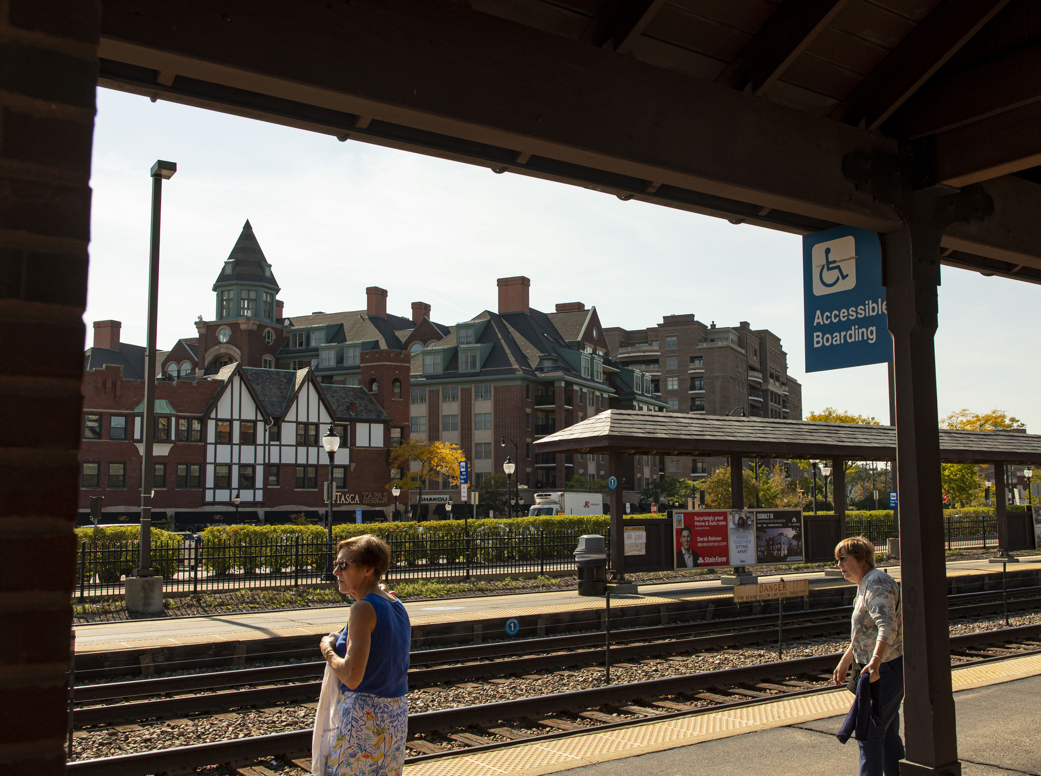 Riders wait for a Metra train at the station in...