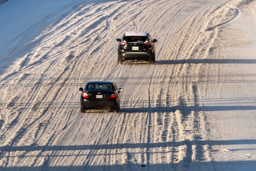 Cars drive over an ice-covered overpass at the I-35W/I-30 Mixmaster interchange, Sunday,...