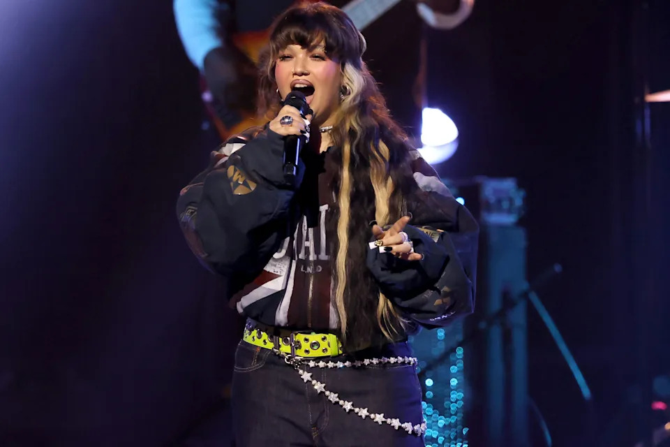 Lola Young performs onstage.
