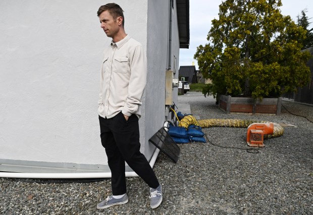 K.C. Pedersen, vice president at Clipper Yacht Harbor, walks outside one of his properties on Gate 5 Road in Sausalito, Calif., on Wednesday, Jan. 21, 2026. The fan behind him is airing out the building from tidal flooding. (Alan Dep/Marin Independent Journal)