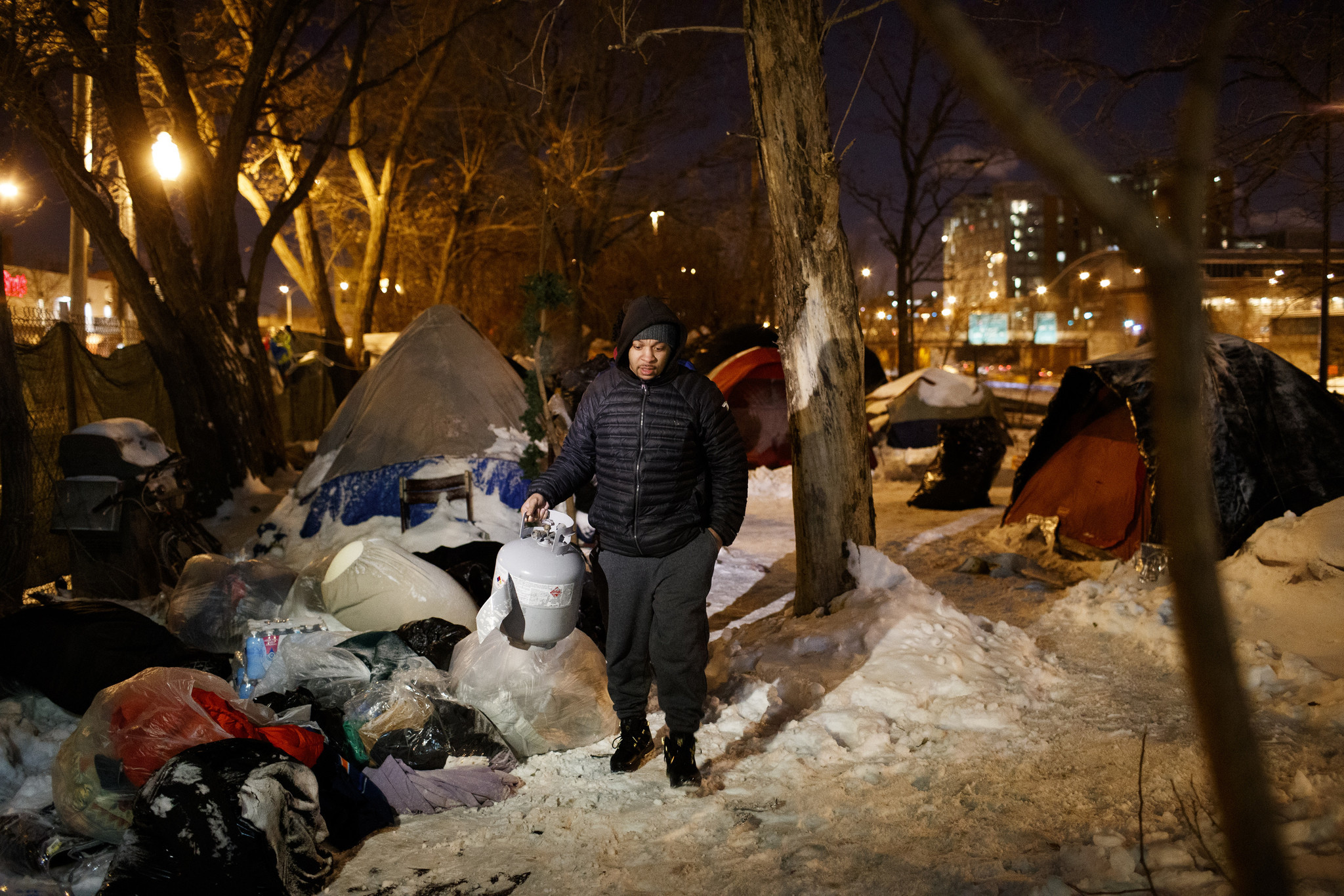 A man carries a propane tank he brought to donate...