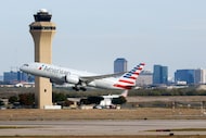 An American Airlines jet takes off past the control tower at DFW Airport, Nov. 27, 2023.