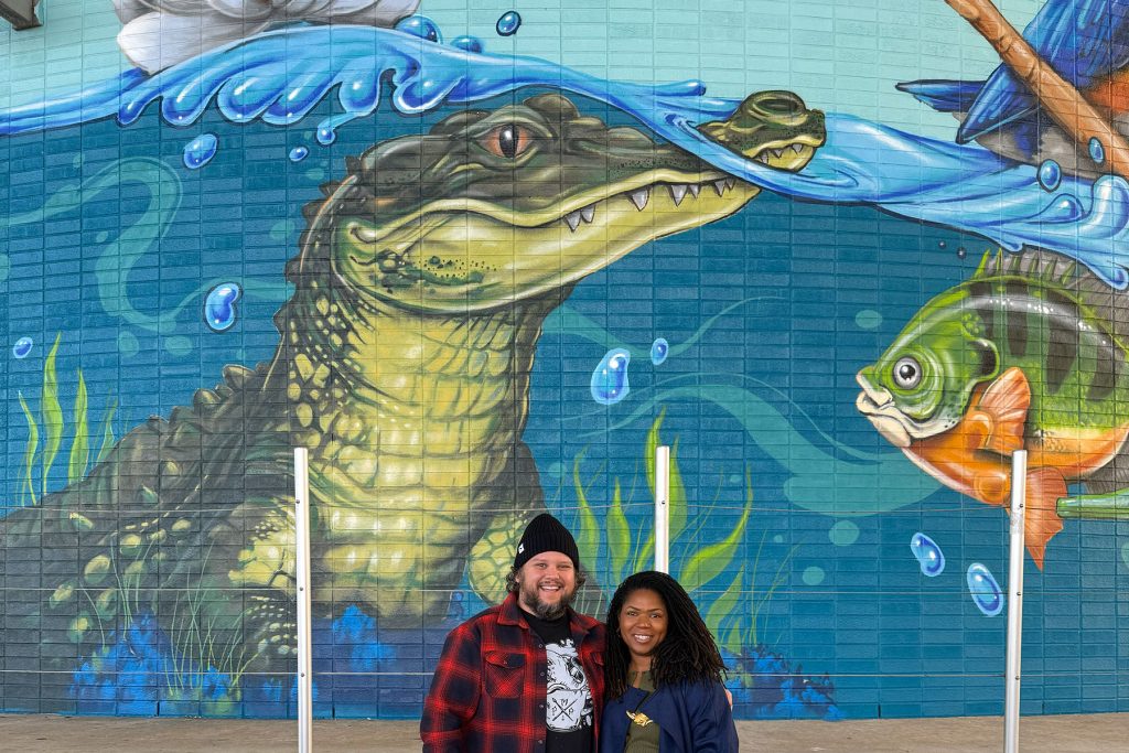Artist Patrick Maxcy and RAP Creating Placemaking Specialist Kandice Clark post before a section of “Abundant Waters” at the Dec. 12 mural unveiling.