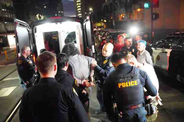 San Diego Police officers bring the arrested protestors to the police van at City Administration Building on Friday, Jan. 23, 2026 in San Diego, CA. (Michael Ho / For The San Diego Union-Tribune)