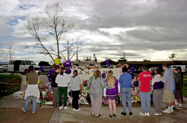 Community members along with students from Santana High come to the entrance of the school to place flowers and pray for those injured and fatally shot. (Nelvin C. Cepeda / U-T file)