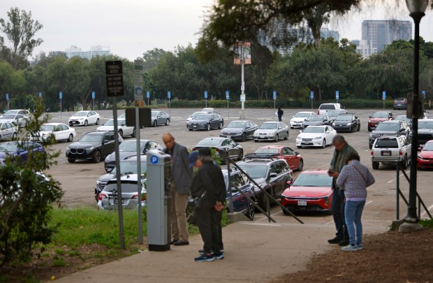 San Diego, CA - January 21: Visitors try to figure out a parking machine near a half-empty Organ Pavilion Lot in Ballboa Park on January 21, 2026 in San Diego, CA. The city recently implemented paid parking in the park and which has deterred visitors.  (K.C. Alfred / The San Diego Union-Tribune)